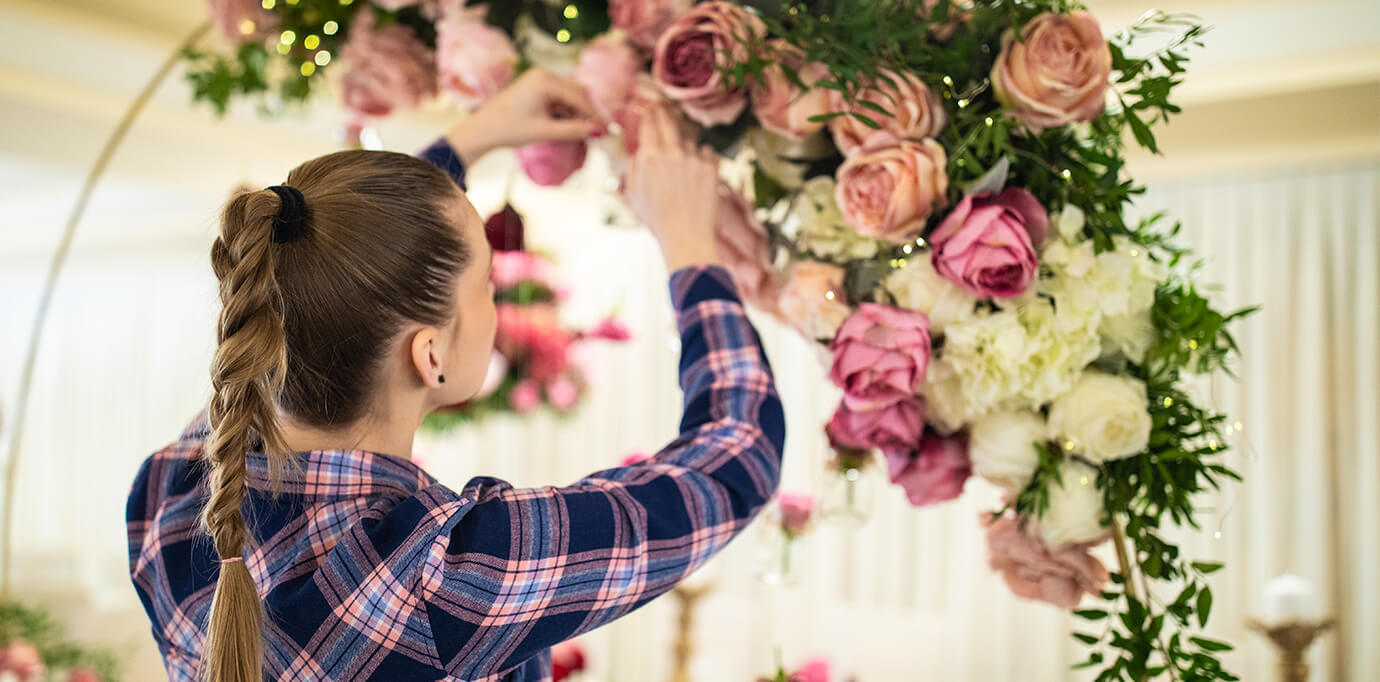organizadora de eventos decorando con flores un salón