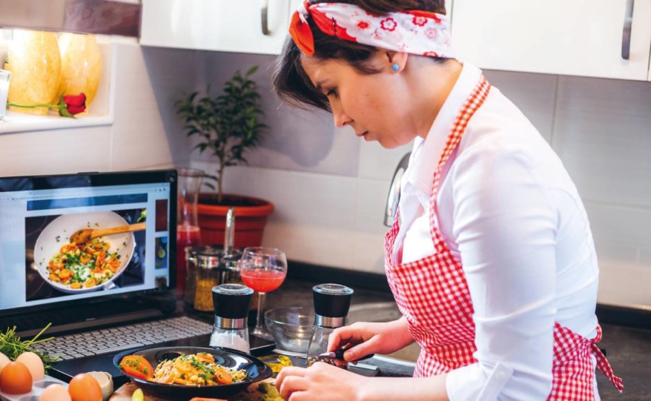 Mujer cocinando siguiendo las lecciones de un curso de cocina online