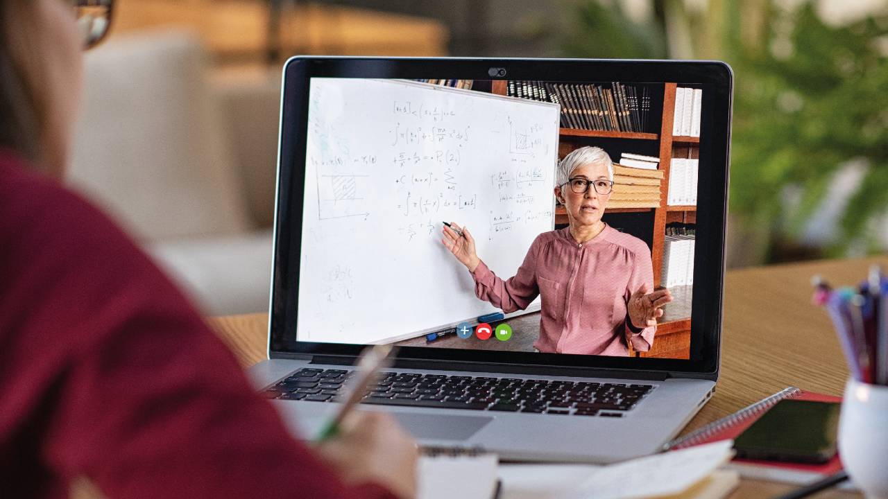 Mujer en una pantalla enseñando en su curso en línea