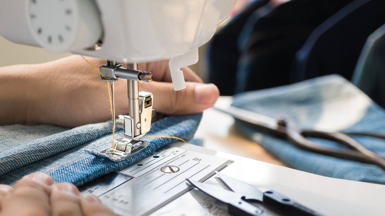 Manos de una mujer utilizando una máquina de coser