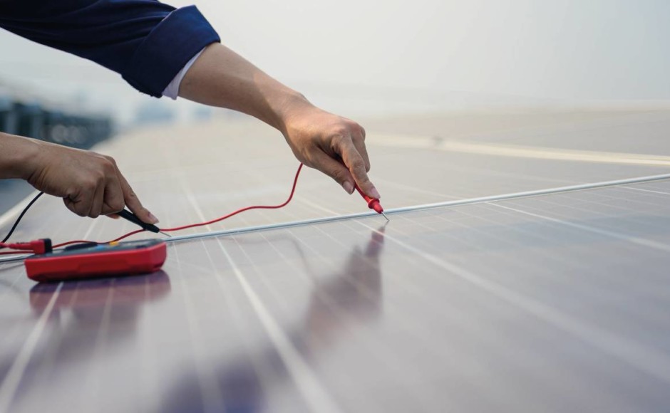 Hombre midiendo la intensidad eléctrica en un panel solar previo a realizar un mantenimiento preventivo