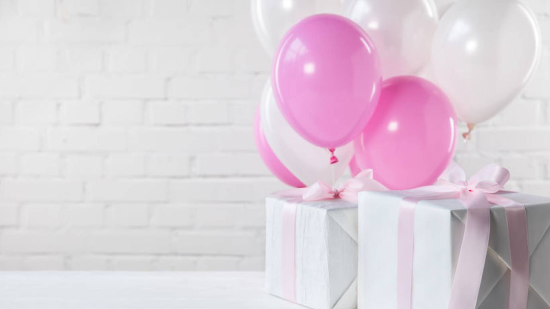 Cajas de regalo y globos rosados
