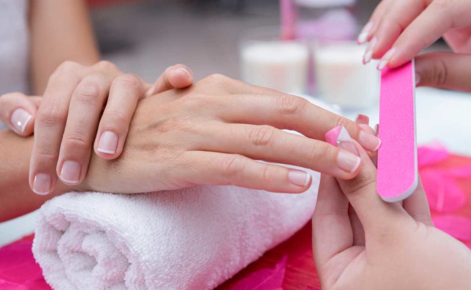 Manos de una mujer a la que se le está aplicando manicure