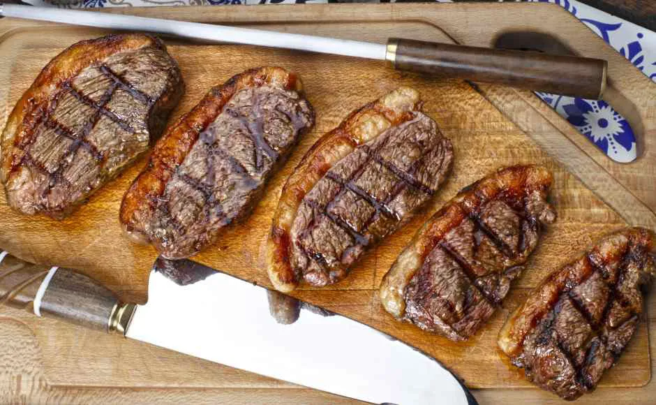lonjas de bife de carne sobre una tabla de madera