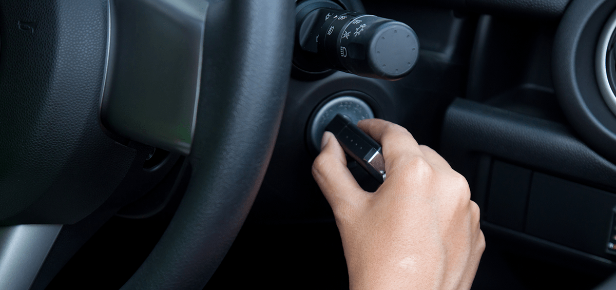 imagen de una mano introduciendo una llave en el sistema de encendido de un auto