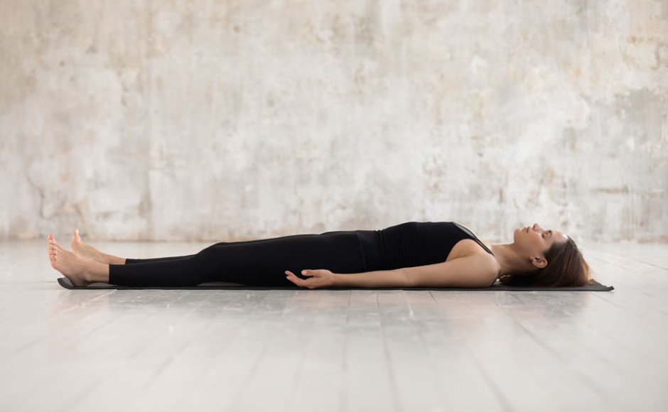 mujer acostada en el piso practicando meditacion o yoga