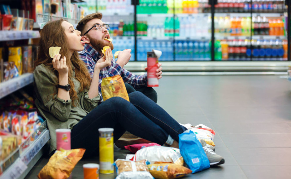 pareja sentada en un supermercado comiendo comida rapida