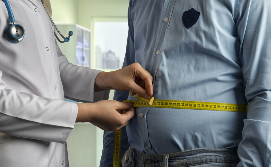 doctor midiendo la cintura de un hombre