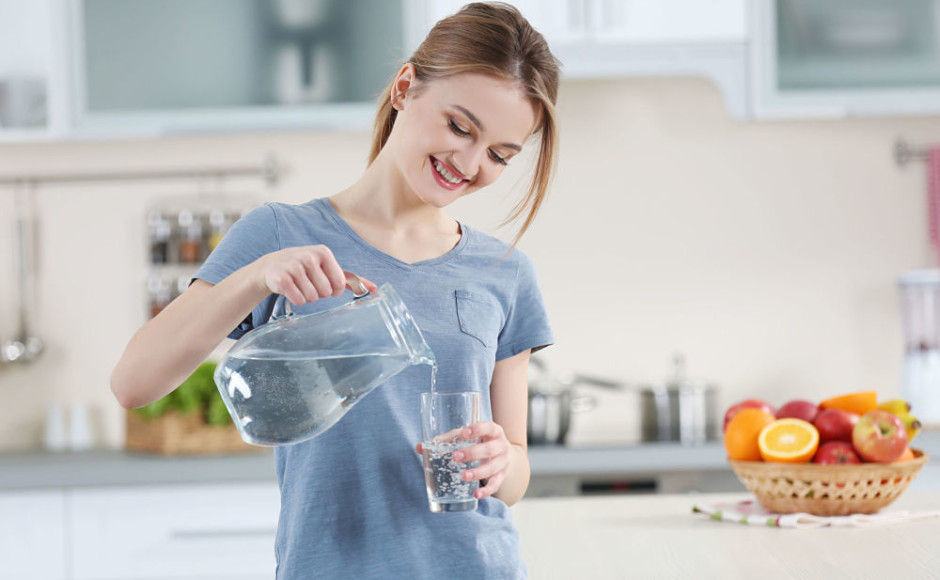 mujer feliz sirviendo un vaso con agua