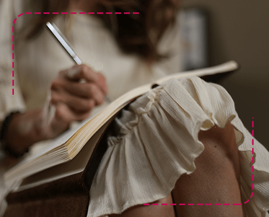 mujer escribiendo en una libreta sobre sus piernas
