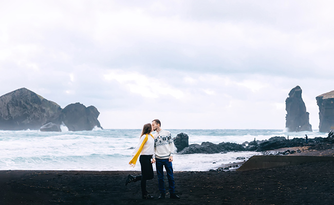 pareja en una playa con arena negra en Islandia