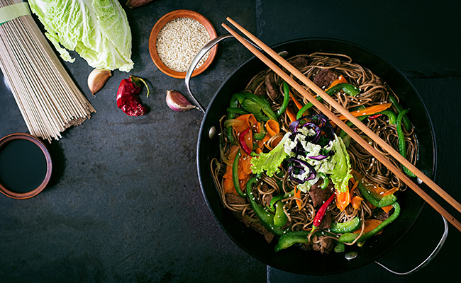 imagen desde arriba de un wok con diversos vegetales y carne listo para comer