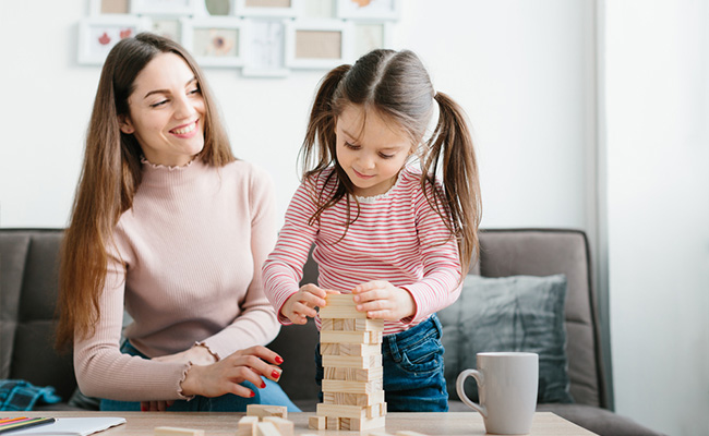 madre jugando con su hija y bloques de madera