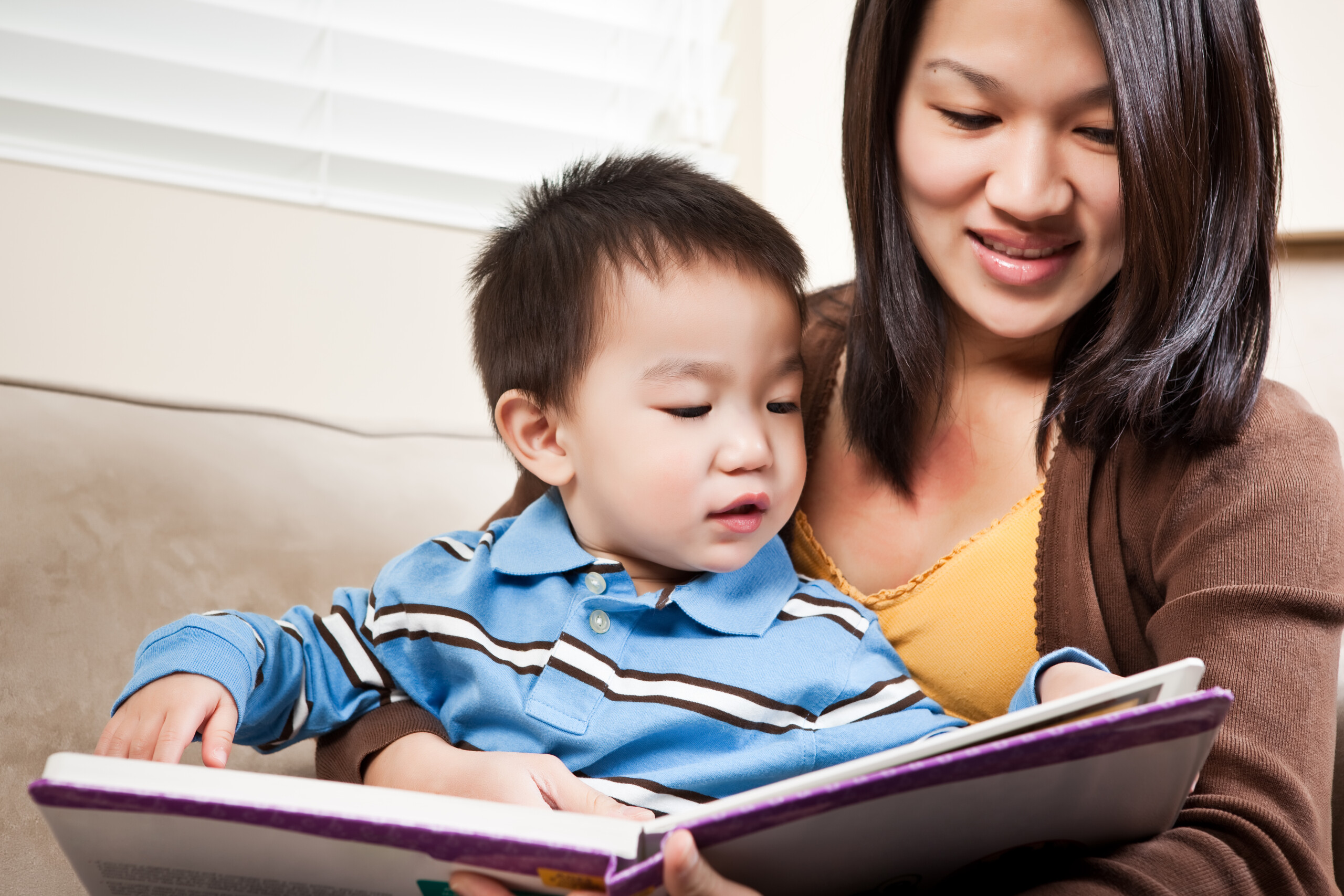 mamá enseñando a leer a su hijo pequeño