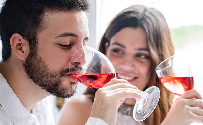 Dos personas disfrutando una copa de vino tinto