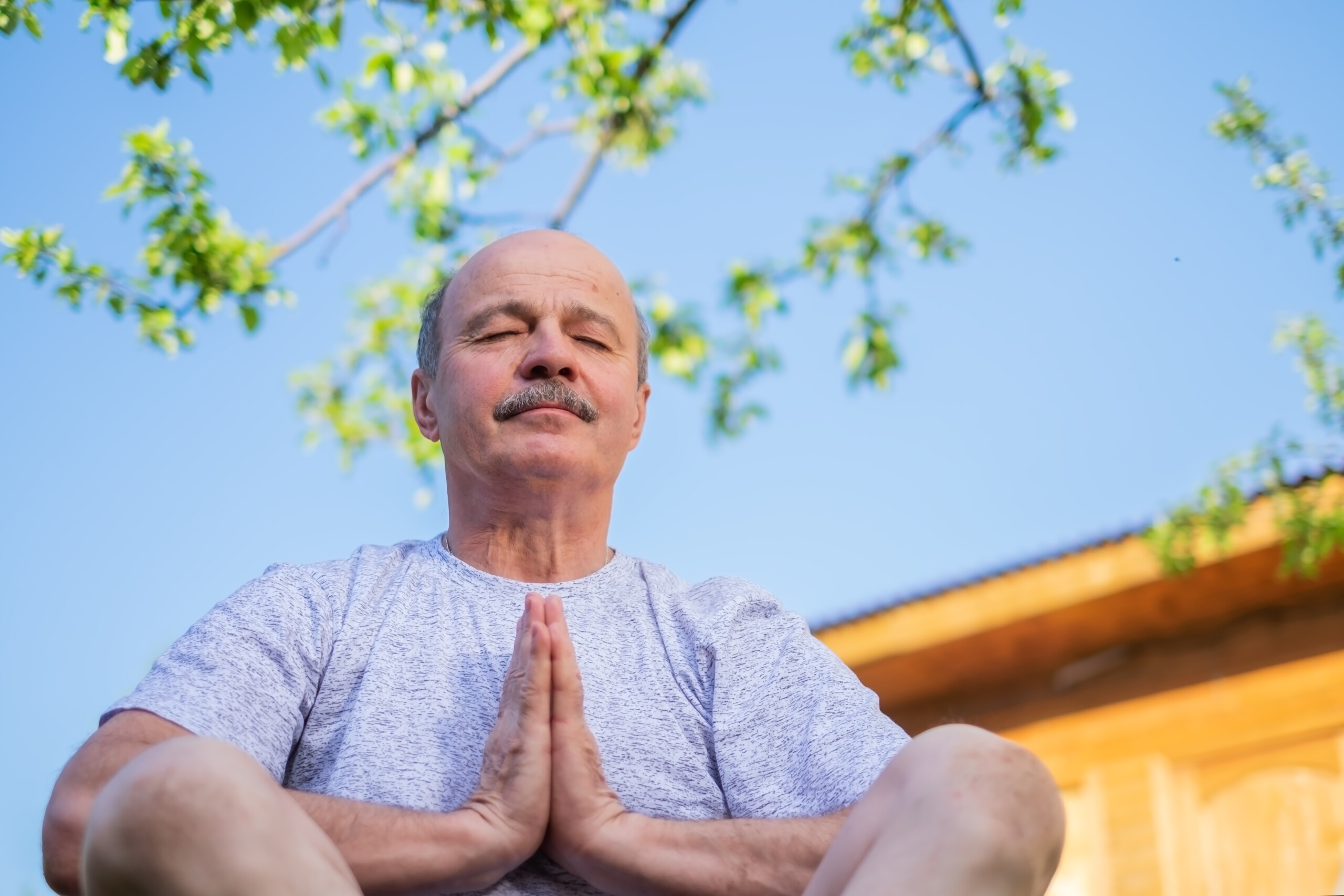 adulto mayor meditando al aire libre