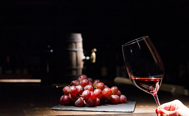  copa de vino junto a racimos de uvas a su alrededor