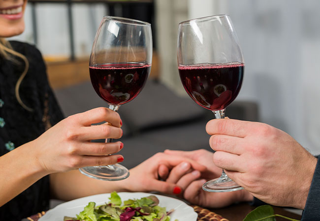 personas brindando con un vino merlot en una cena
