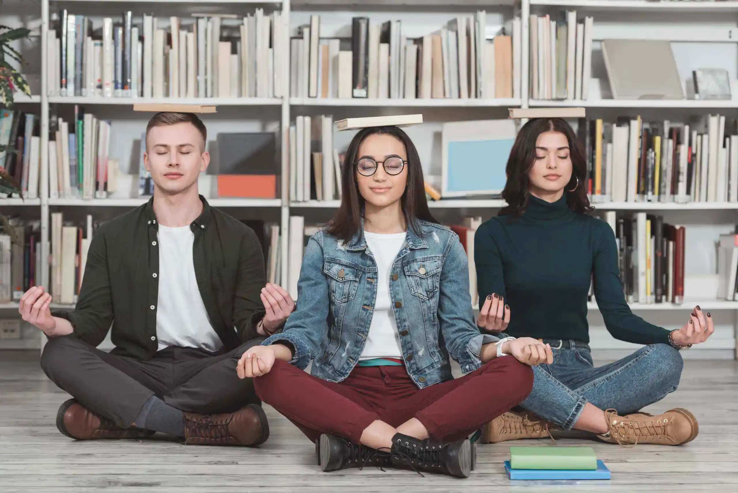 estudiantes meditando en una habitación repleta de libros