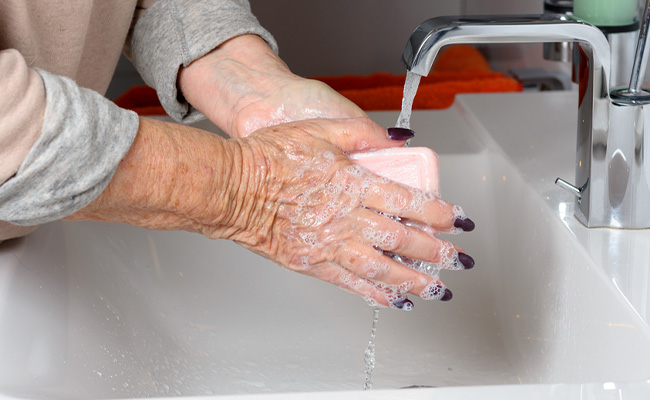 adulto mayor lavandose las manos