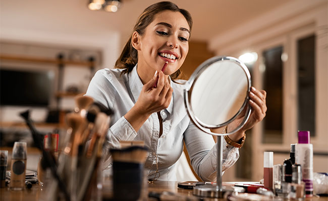 mujer maquillandose frente al espejo