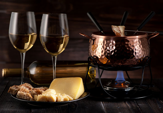 dos copas de vino al lado de una fondue