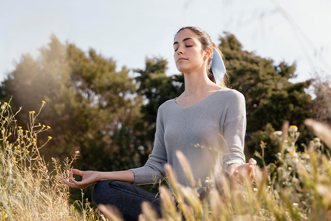 persona realizando una meditación al aire libre