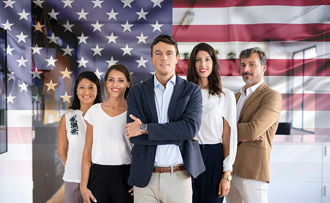 emprendedor junto a equipo de trabajo y la bandera de Estados Unidos de fondo