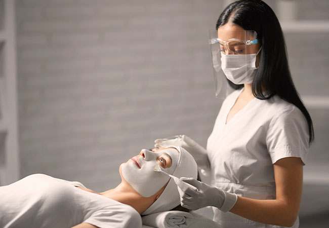 profesional cosmetologa realizando un tratamiento facial