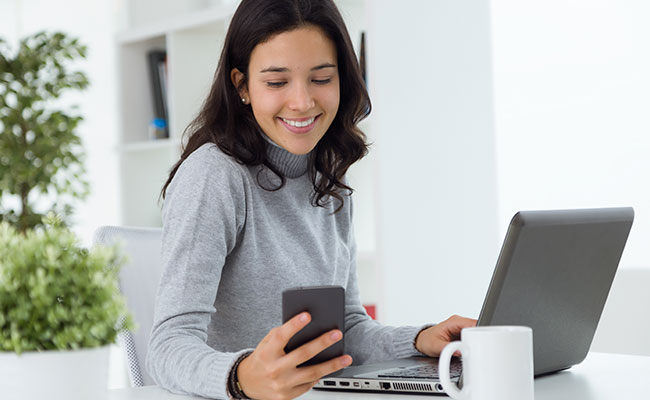 mujer preparandose para ver un webinar con su computadora y celular