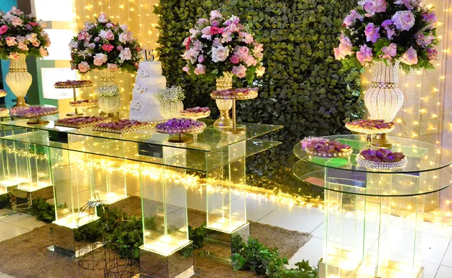 mesa de cristal con flores y pasteles de decoracion