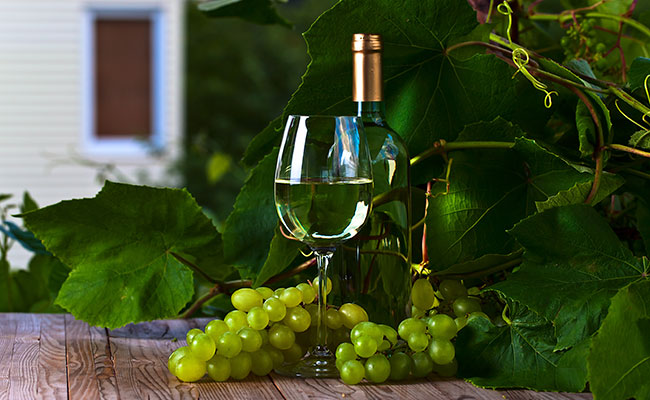  Foto de un vino blanco rodeado de unas uvas verdes