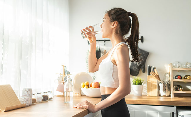 mujer hidratandose en la cocina
