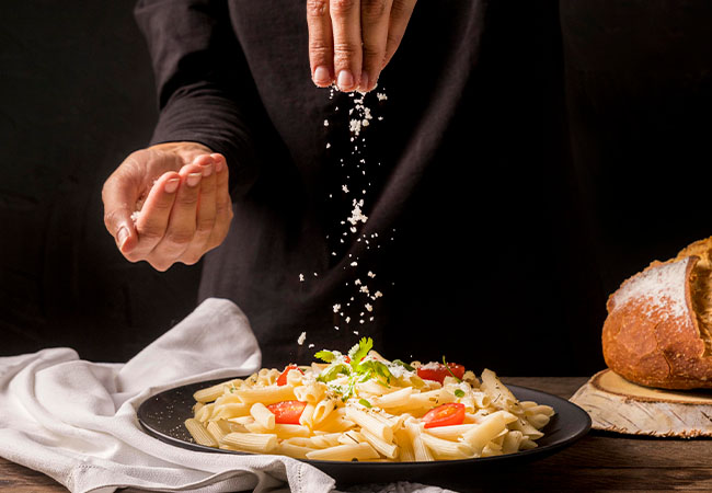 persona cocinando un plato italiano en su cocina