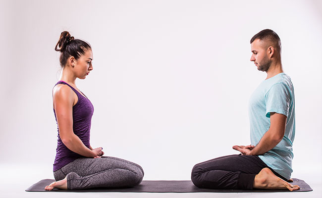 personas en una clase de yin yoga junto a un profesor