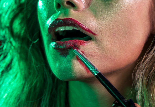 mujer aplicando sangre falsa en su maquillaje