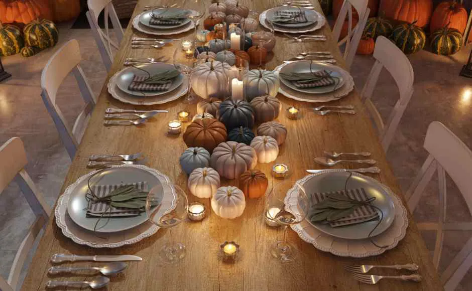 mesa decorada con platos, calabazas y velas