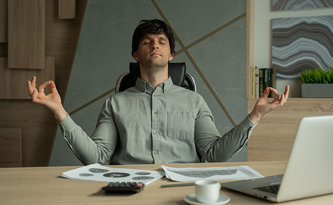 hombre meditando frente a su escritorio