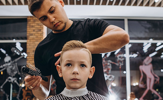 peluquero cortando el cabello a un niño
