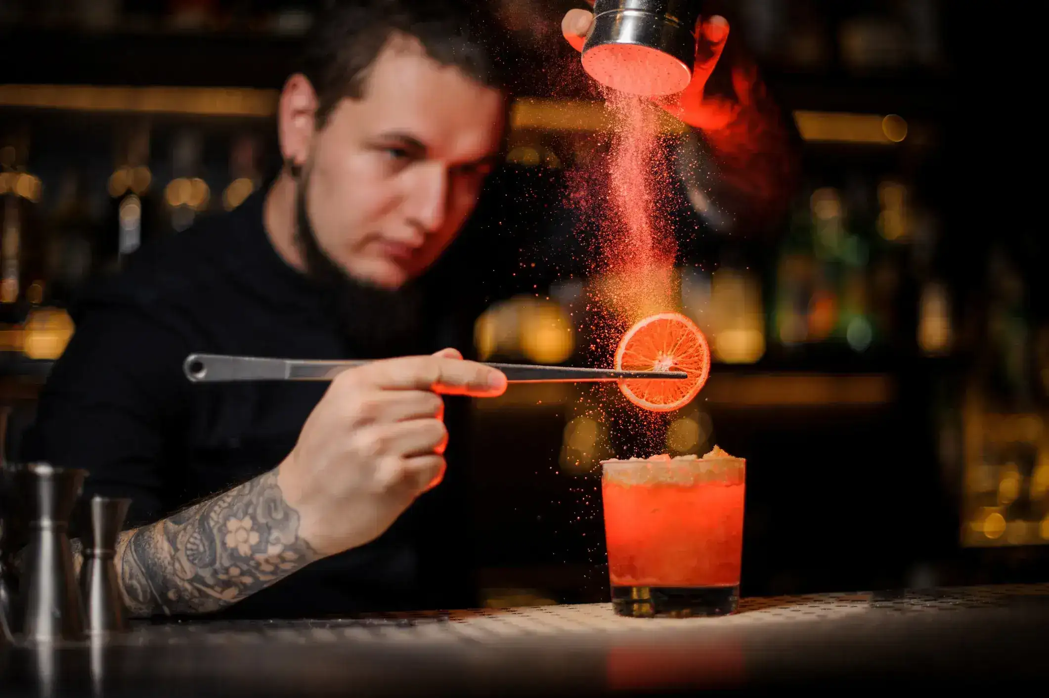 bartender poniendo un garnish en un trago