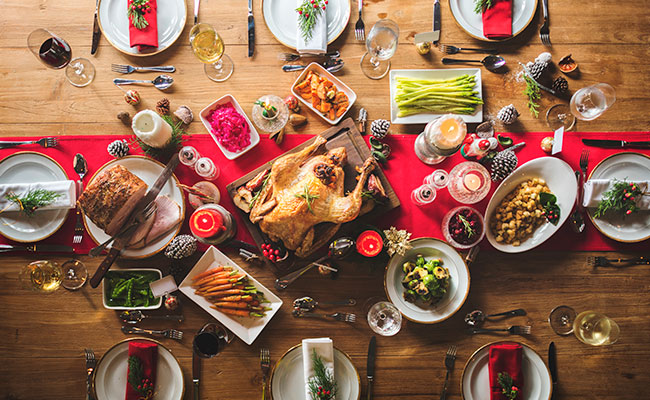 mesa larga llena de platillos navideños tipicos