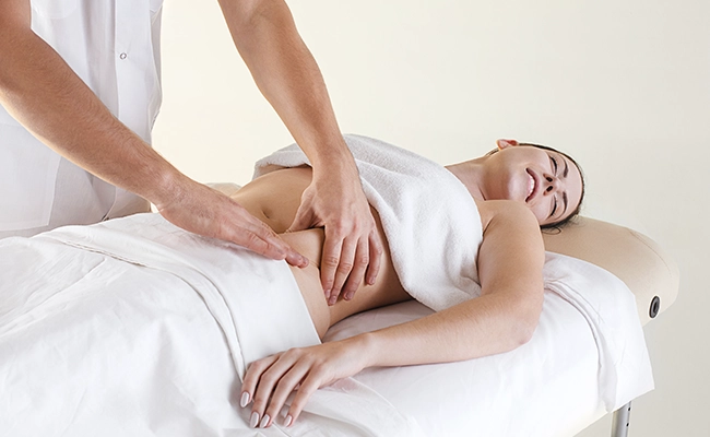 mujer relajada recibiendo un masaje abdominal