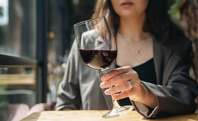 mujer mirando una copa de vino antes de degustarla