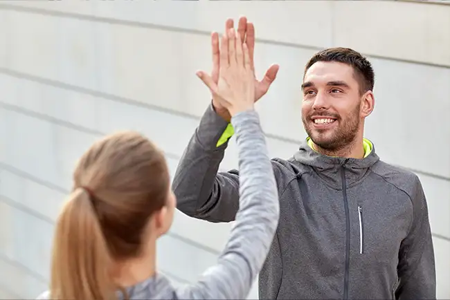Entrenador fitness chocando las manos con su alumna