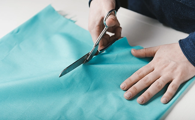 manos cortando un pedazo de tela